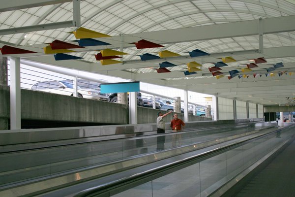 The powder coat painted aluminum airplanes fly above a walkway at the Jacksonville International Airport.