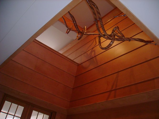 Three laminated wood sculptures of pelicans descend from an upper level of the house.