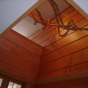 Three laminated wood sculptures of pelicans descend from an upper level of the house.