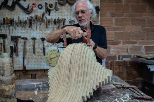 David Engdahl applies a clamp to a laminated wood sculpture he's working on.