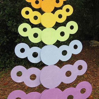 A rainbow-colored tree made of wood circles.