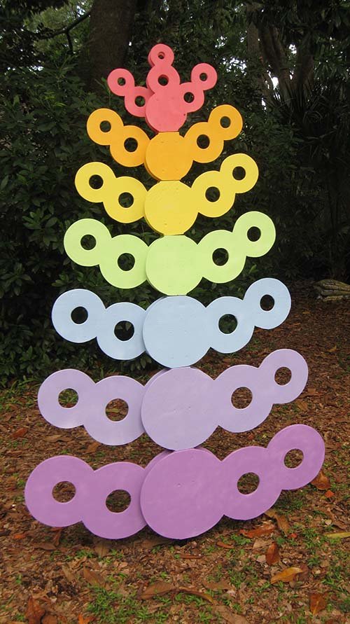 A rainbow-colored tree made of wood circles.