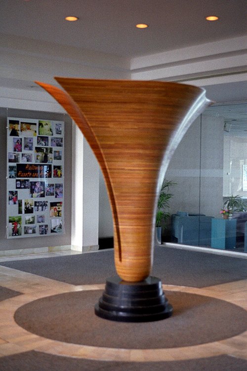 A large, fluted laminated wood sculpture that is split down the middle.