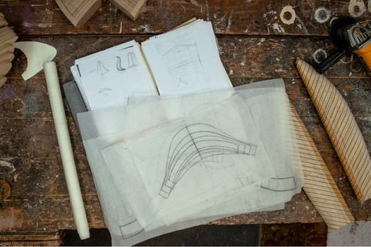 Sketches, contour drawings and half-completed sculptures on a work table.
