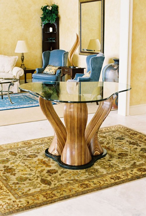 Laminated wood sculpture base for a shaped glass table.