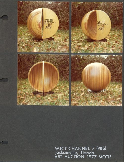 Laminated wood sculpture that is half of a hollow sphere with a narrow arch with printed words: "Salute to the Arts."