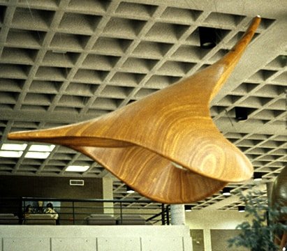 Laminated wood sculpture that is arched up to imply ascent.